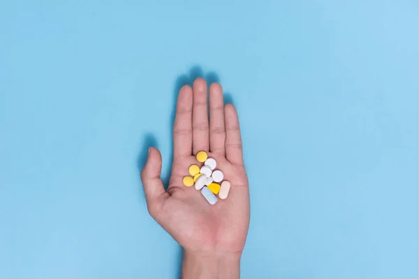 Píldoras de color en la mano — Foto de Stock