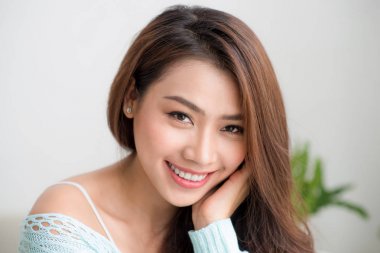 Gülümseyen genç Asyalı kadın yeşil taze sebze suyu o içme