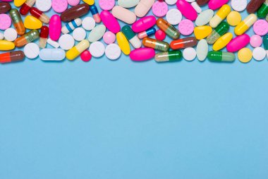 Mavi arka plan üzerinde renkli hapları.