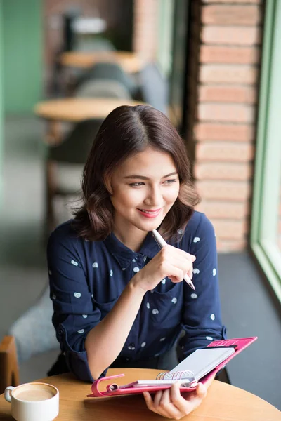 Woman with pen and notebook — Stock Photo, Image