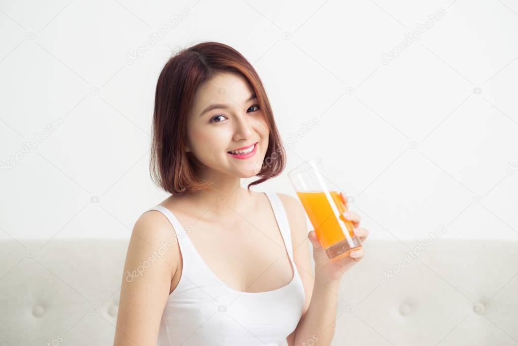 Portrait of a beautiful young asian woman having orange juice.