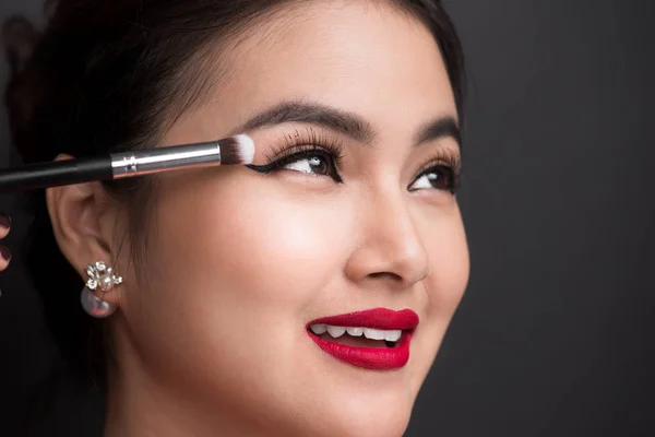 Wanita menerapkan eyeshadow pada kelopak mata . — Stok Foto