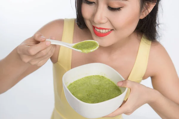 Kvinna äta tallrik grön soppa — Stockfoto