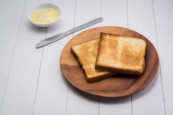 Toasts on plate with butter — Stock Photo, Image