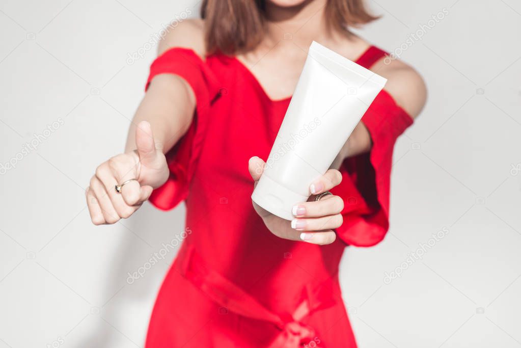 girl holding cosmetic plastic tube