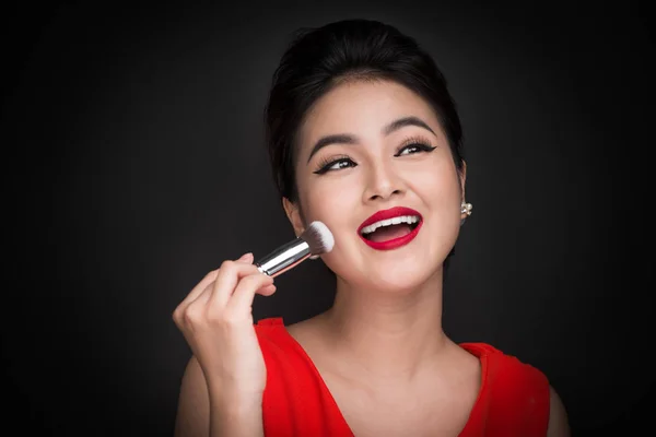 Wanita menerapkan blusher di pipinya — Stok Foto