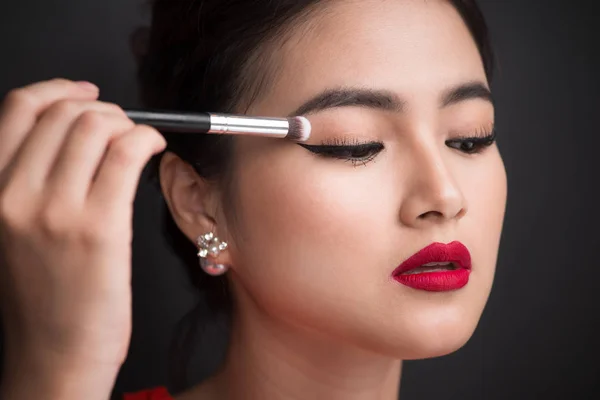 Woman applying eyeshadow on eyelid. — Stock Photo, Image