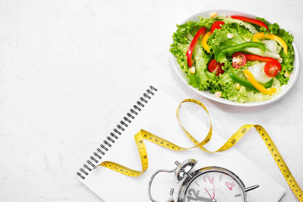 свежий салат, лента и блокнот
