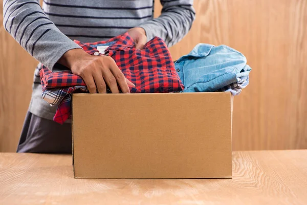 Caja con ropa en manos masculinas — Foto de Stock