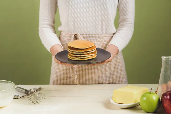 Mujer sosteniendo placa con panqueques . — Foto de Stock