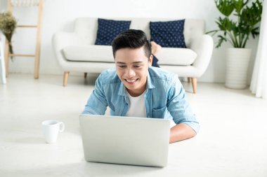 Laptop ile katta yatan adam