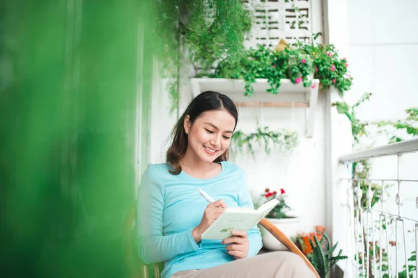 Donna con libro sul balcone — Foto Stock