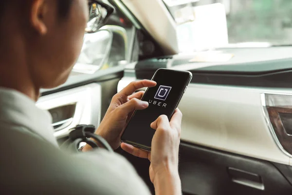 Человек с помощью приложения Uber на смартфоне — стоковое фото