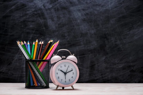 Красочные карандаши и часы — стоковое фото