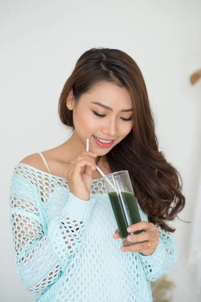 Женщина пьет зеленый сок — стоковое фото
