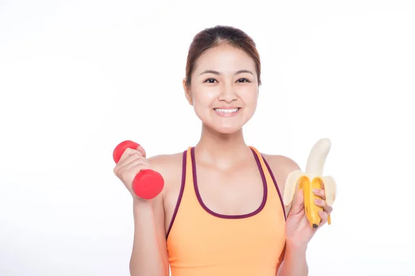 Vrouw bedrijf banaan en halter — Stockfoto