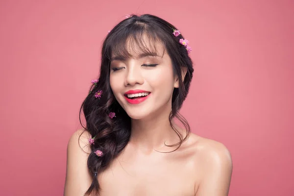 Brunett kvinna med rosa blommor på hår — Stockfoto