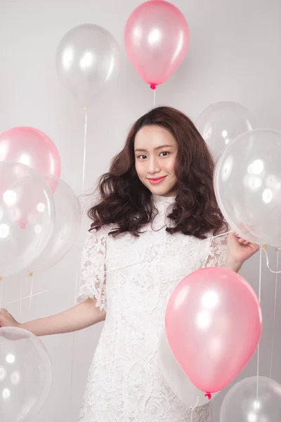 brunette woman with pastel balloons