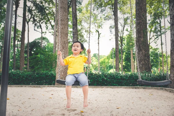 Мальчик, качающийся на детской площадке — стоковое фото