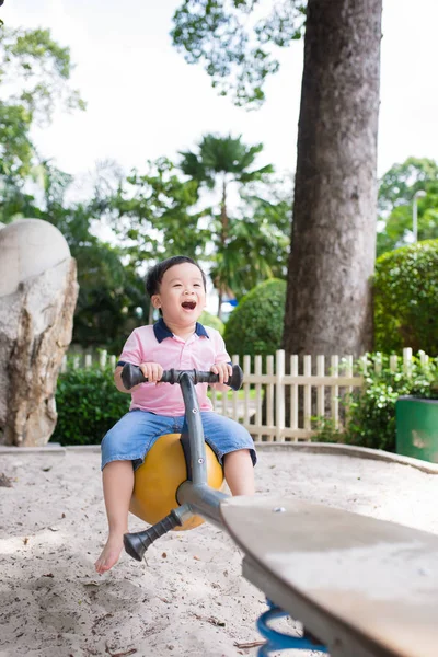 Little boy playing seesaw — Stock Photo, Image