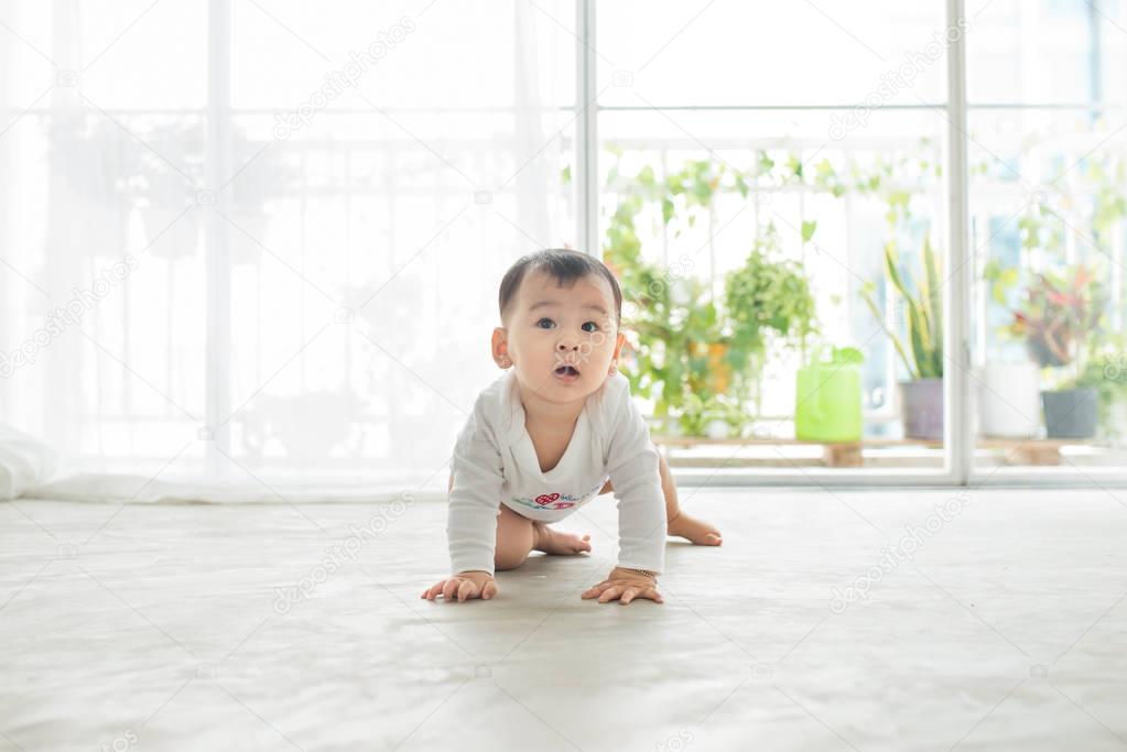 baby girl crawling on the floor at home