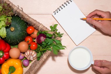 kalem ve defter ile sebze ile el