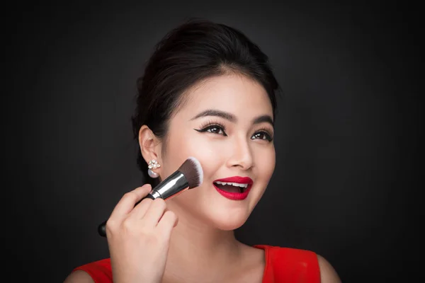 Wanita menerapkan blusher di pipi — Stok Foto