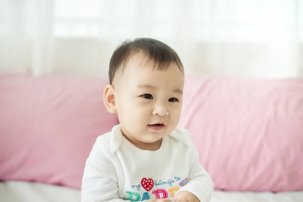 Baby girl sitting on bed — Stock Photo, Image