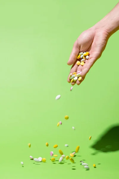Píldoras de color cayendo de la mano — Foto de Stock