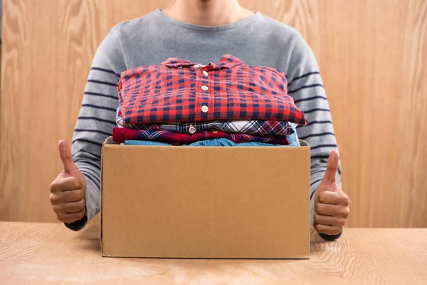 Caja con ropa en manos masculinas — Foto de Stock