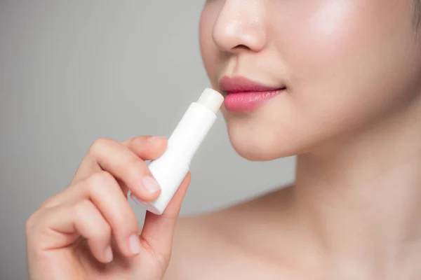 Frau trägt hygienischen Lippenbalsam auf — Stockfoto