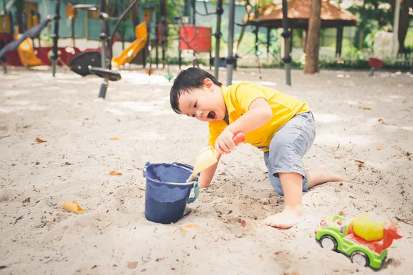 Niño jugando con cubo y arena — Foto de Stock