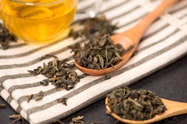 Bir cam bardak ve çay siyah çay tahta kaşık siyah üzerine bırakır.