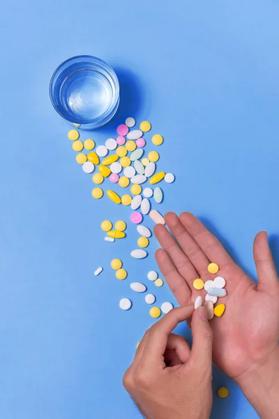 Mano con píldoras y agua — Foto de Stock