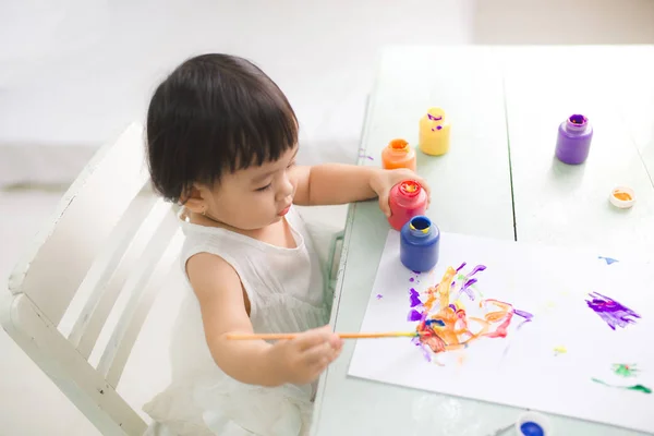 Рисование малышкой с красочной краской — стоковое фото