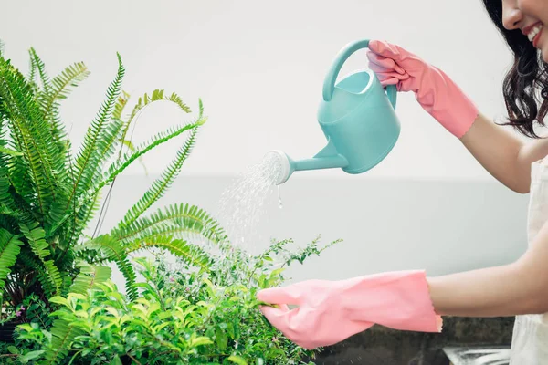 Jonge Aziatische vrouwelijke tuinman met behulp van mobiele telefoon tijdens het drenken th — Stockfoto