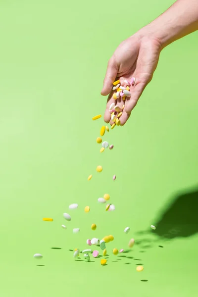 Píldoras de color cayendo de la mano —  Fotos de Stock