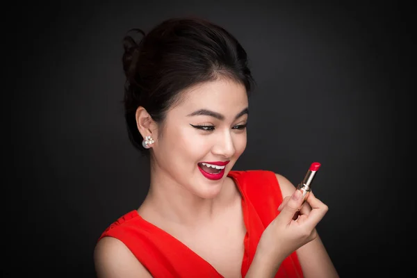 Wanita mengaplikasikan lipstik merah. — Stok Foto