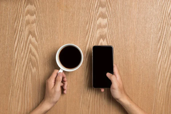 Handen met koffie en smartphone — Stockfoto