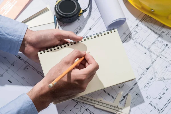 Bezig met blauwdrukken. Bouwproject met handen schrijven o — Stockfoto