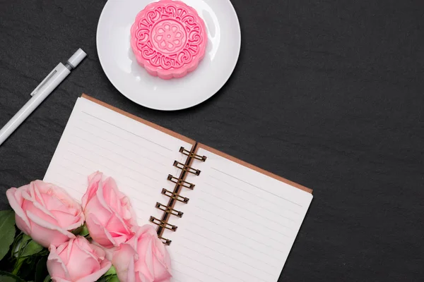 Pastel de luna de piel de nieve y flores rosadas sobre fondo oscuro. Abierto no — Foto de Stock