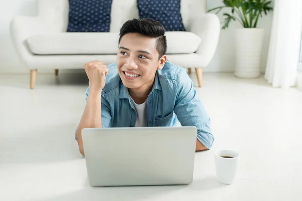 Homem deitado no chão com laptop — Fotografia de Stock