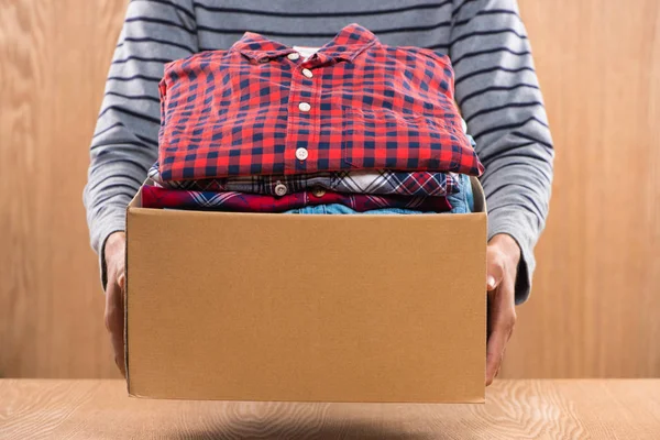 Caja con ropa en manos masculinas — Foto de Stock