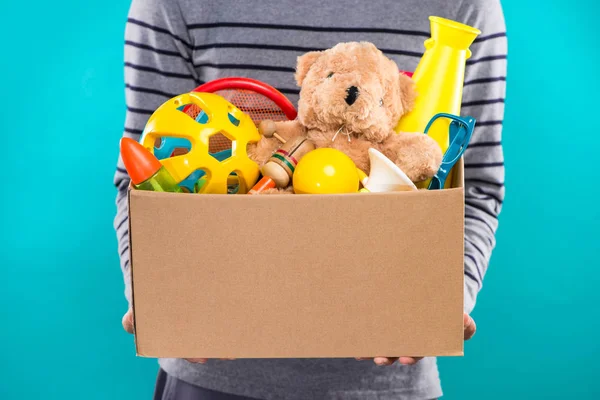 Voluntário segurando caixa com brinquedos — Fotografia de Stock