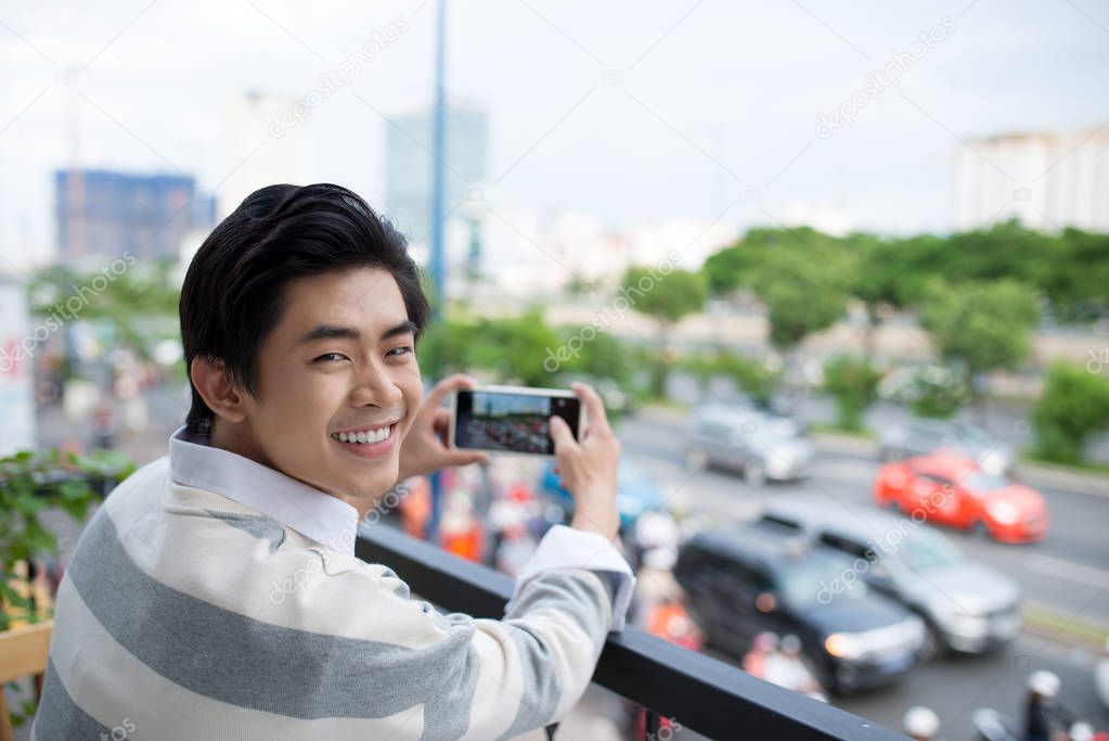 man taking photo of city