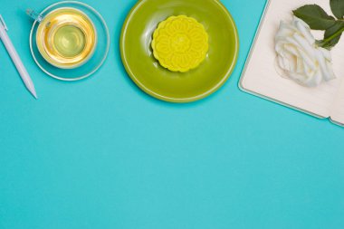 Çiçekler koyu arka plan üzerinde kar cilt mooncake ve çay Kupası. 