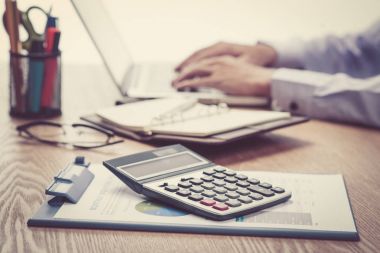 Eller dizüstü bilgisayarda yazıyor.