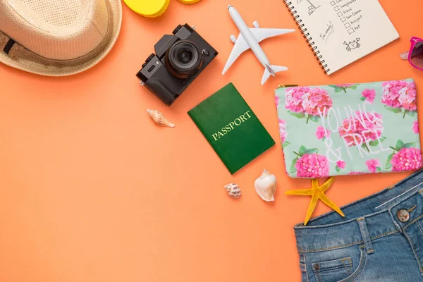 Turuncu zemin üzerine tatil aksesuarları.