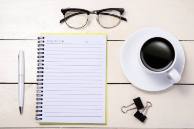 Beyaz ayarlayın. Kalem, gözlük, kahve ve masa üstünde defter. Üstten Görünüm.