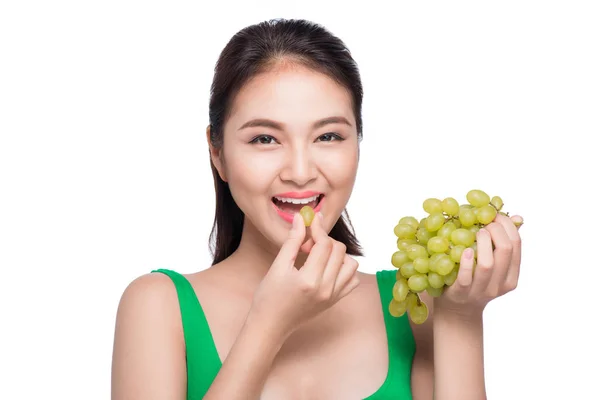 Woman eating green grapes — Stockfoto